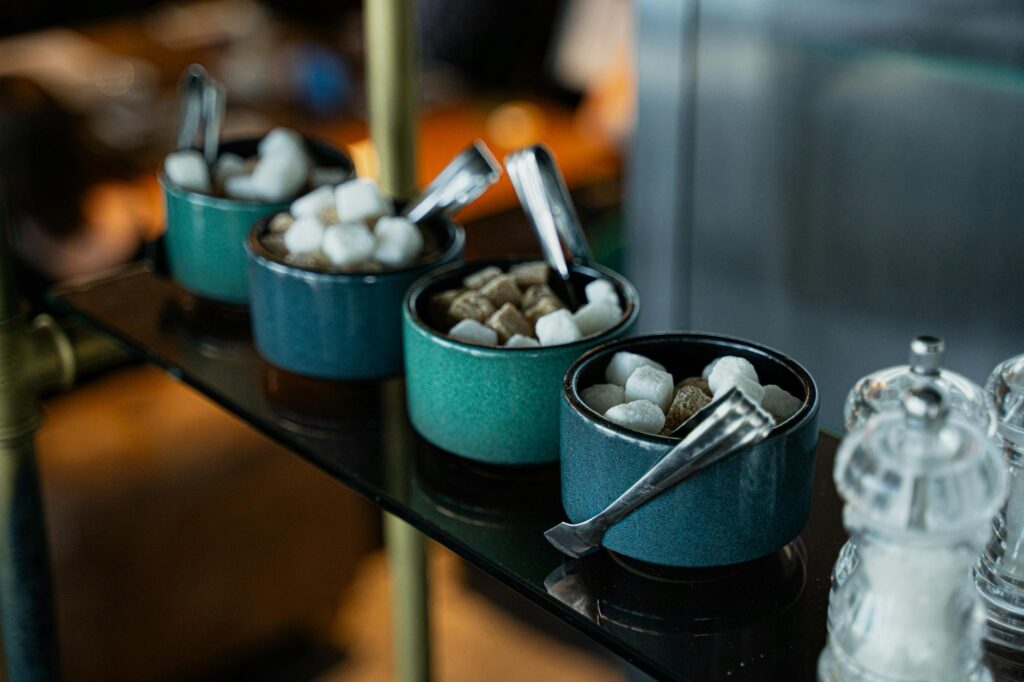 Bols de sucres alternatifs disposés sur une planche en bois près d'un barbecue