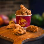 Plateau repas KFC avec wings croustillantes, frites et boisson sur table de fast-food