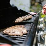 cuisine extérieure avec barbecue encastré et plan de travail en inox au jardin