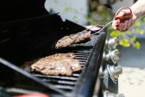 cuisine extérieure avec barbecue encastré et plan de travail en inox au jardin