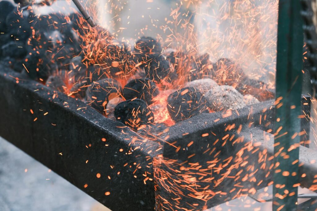 Cheminée d'allumage posée sur grille de barbecue au charbon en extérieur