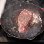 côte de bœuf saisie à la poêle en fonte avec croûte dorée et beurre mousseux