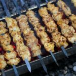 cuisses de poulet dorées sur grille de barbecue avec marinade aux herbes