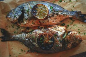 Dorade entière grillée sur barbecue avec citron et herbes fraîches
