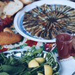 Sardines grillées sur barbecue au charbon avec citron et herbes fraîches