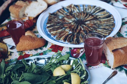 Sardines grillées sur barbecue au charbon avec citron et herbes fraîches