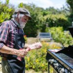 mains qui nettoient une grille de barbecue noircie avec brosse métallique