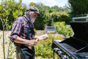 mains qui nettoient une grille de barbecue noircie avec brosse métallique