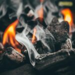 Barbecue à charbon avec braises rougeoyantes en fin de cuisson dans un jardin