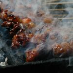 Brochettes colorées de légumes et crevettes marinées sur un barbecue au charbon en plein air