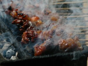 Brochettes colorées de légumes et crevettes marinées sur un barbecue au charbon en plein air